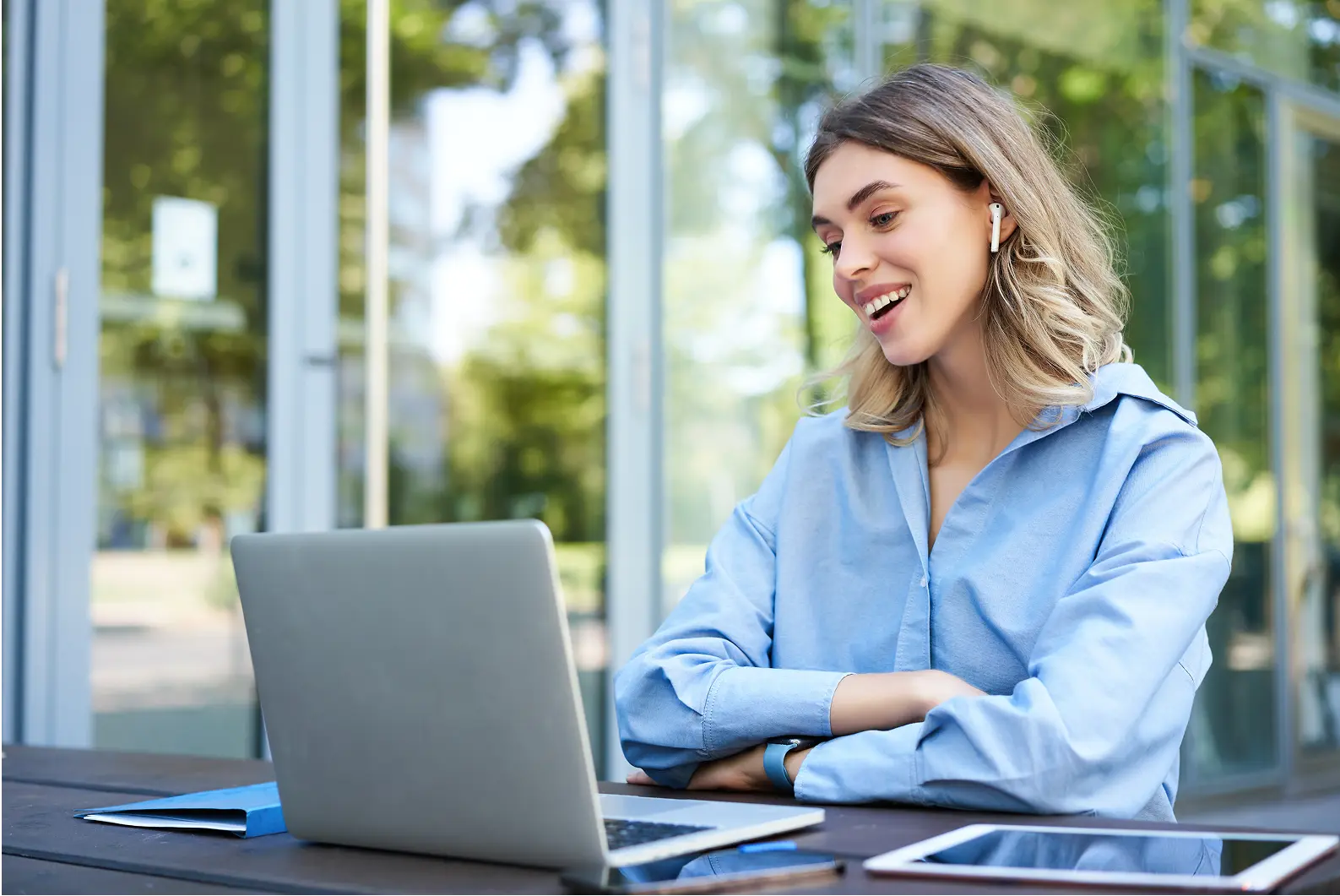 Mujer sonriendo trabajando con su laptop